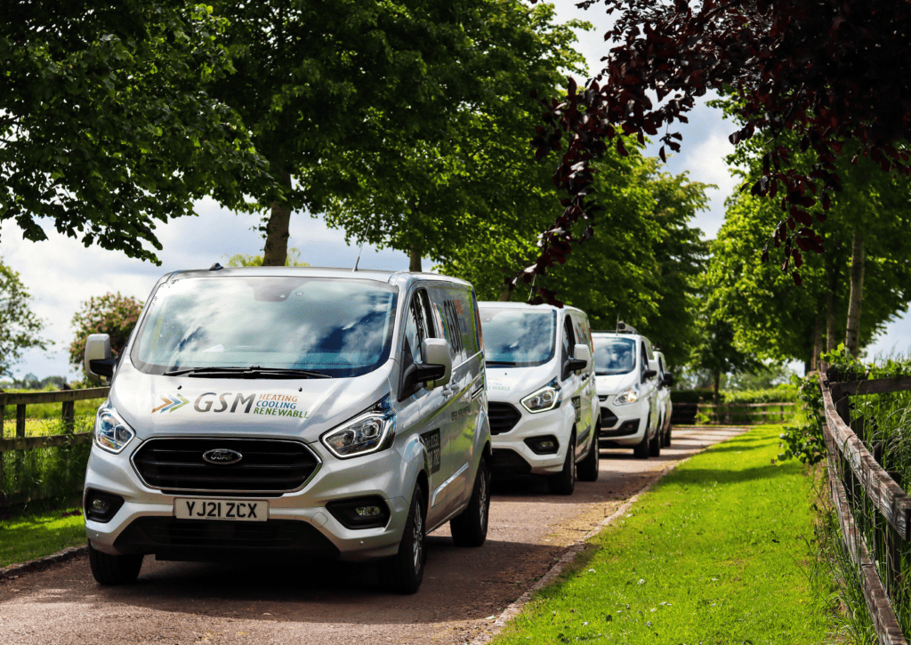 A line of GSM van's along a contry lane.